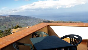 A terrace with a table and chairs, overlooking a coastal landscape with mountains and the sea. - Holiday Home 'Paese Albergo - Arconides' with Sea View, Balcony and Wi-Fi (Motta D'affermo)