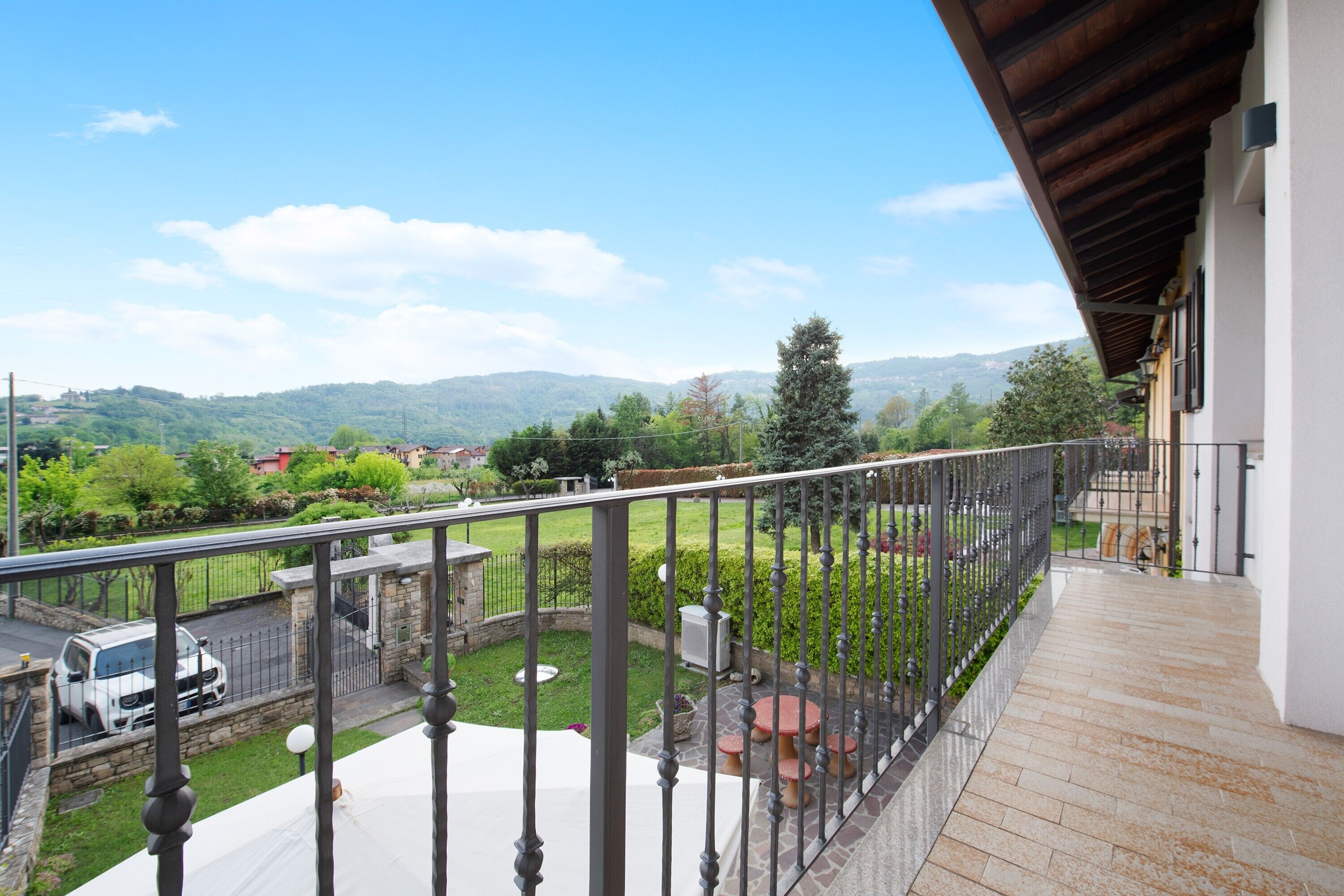 Un balcón con vista a un paisaje verde y colinas lejanas.