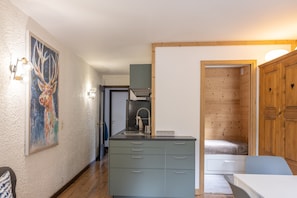 A compact kitchen with a sink, cabinets, and a dining area.
