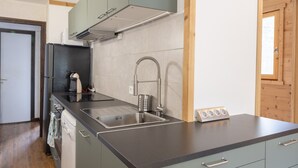 Une cuisine moderne dotée d’un évier en acier inoxydable, d’un four encastré et d’un lave-vaisselle.