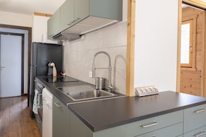 A modern kitchen with a stainless steel sink, a built-in oven, and a dishwasher.