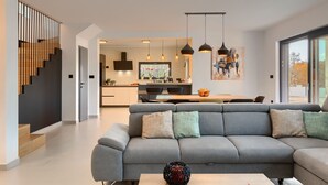 A modern living room with a grey sofa, a coffee table, and a staircase with wooden steps. - In a Small Village Surrounded by Nature (Barban)