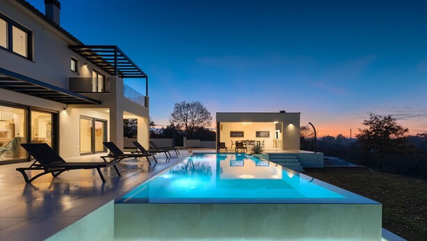 A modern house with a swimming pool, outdoor seating, and a well-lit patio area. - In a Small Village Surrounded by Nature (Barban)