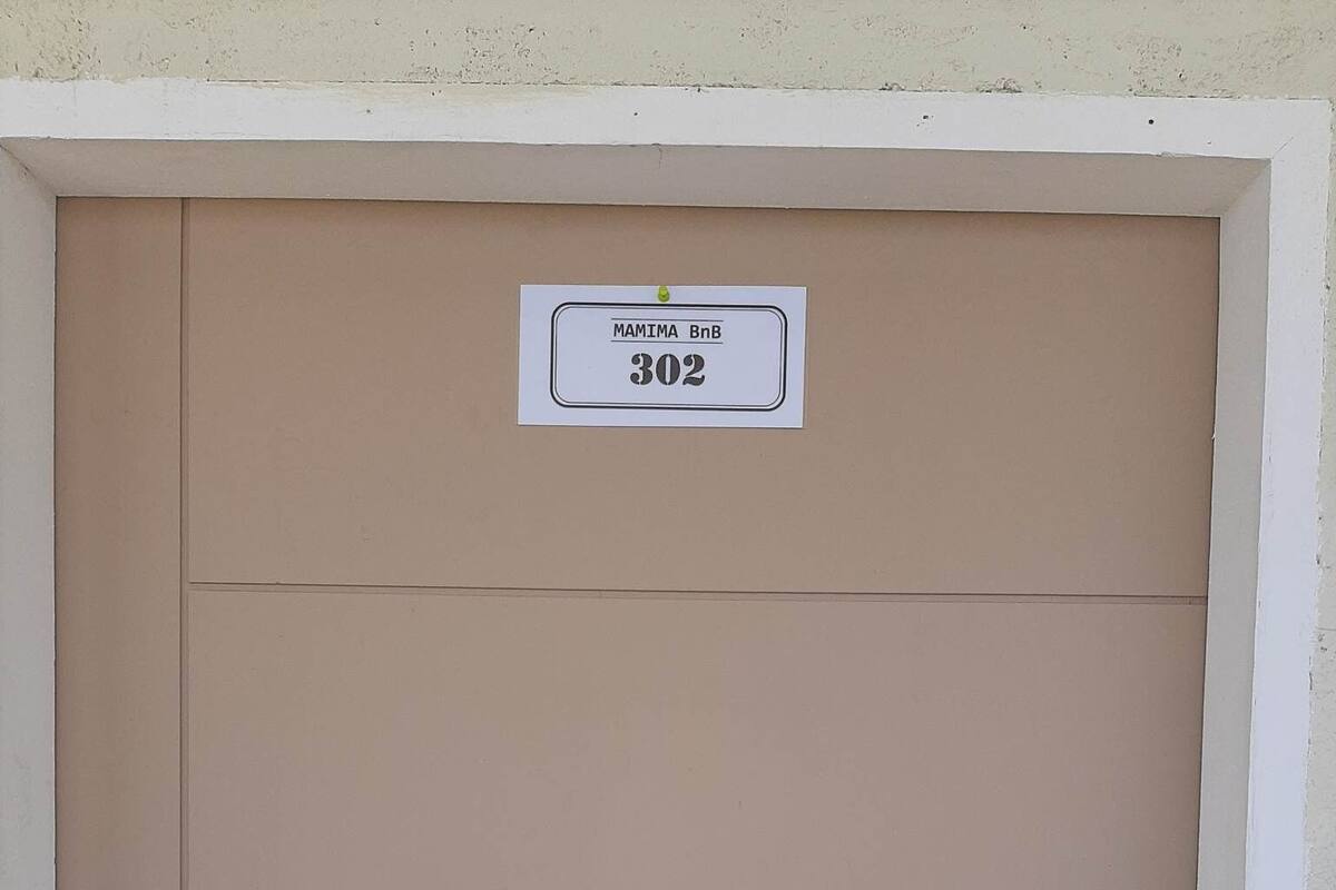 A beige door with a sign reading "MAMIMA BnB 302".