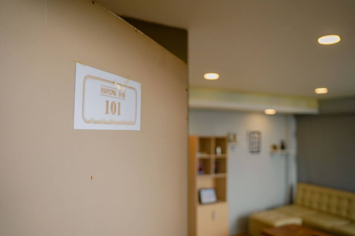 A hallway with a sign reading "MAMIMA B&B 101".