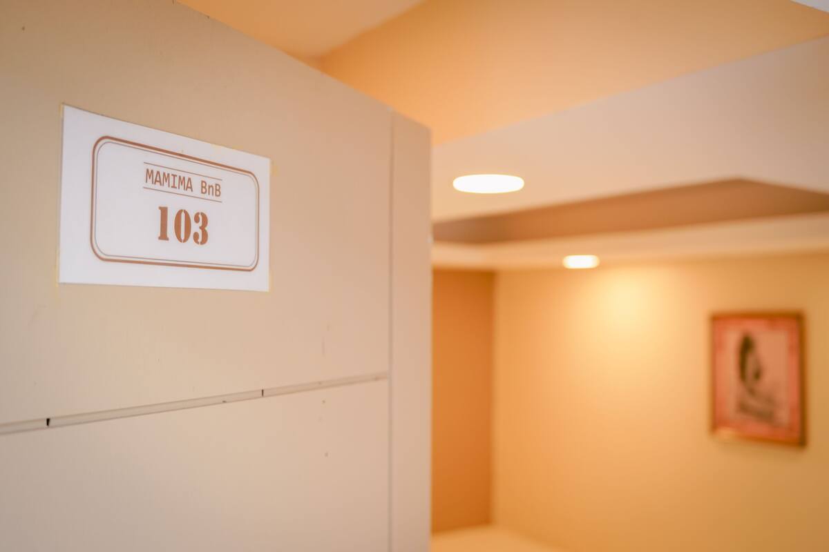 A wall with a sign indicating room number 103 and the name 'MAMIMA BnB'.