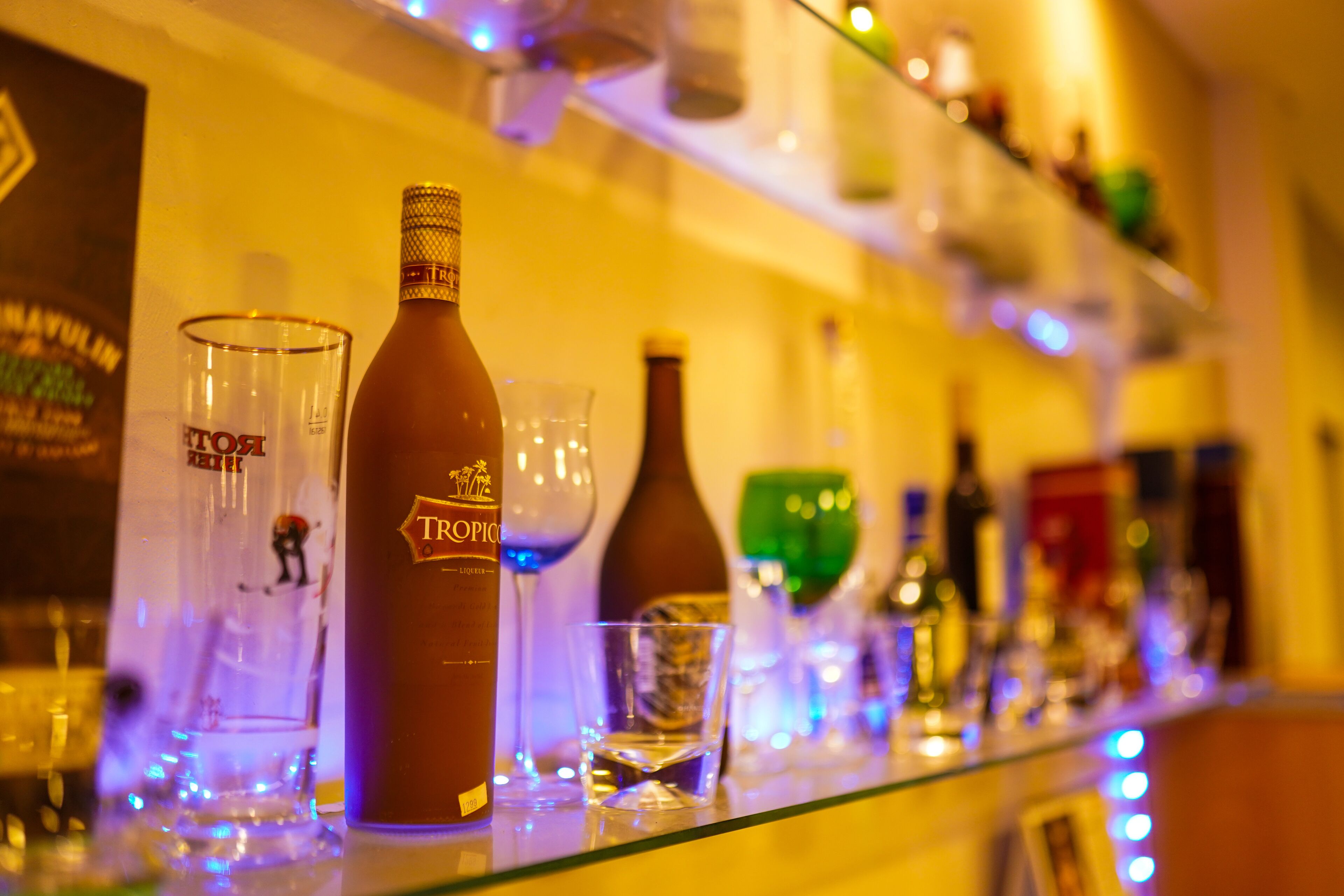A bar with various bottles and glasses on display.