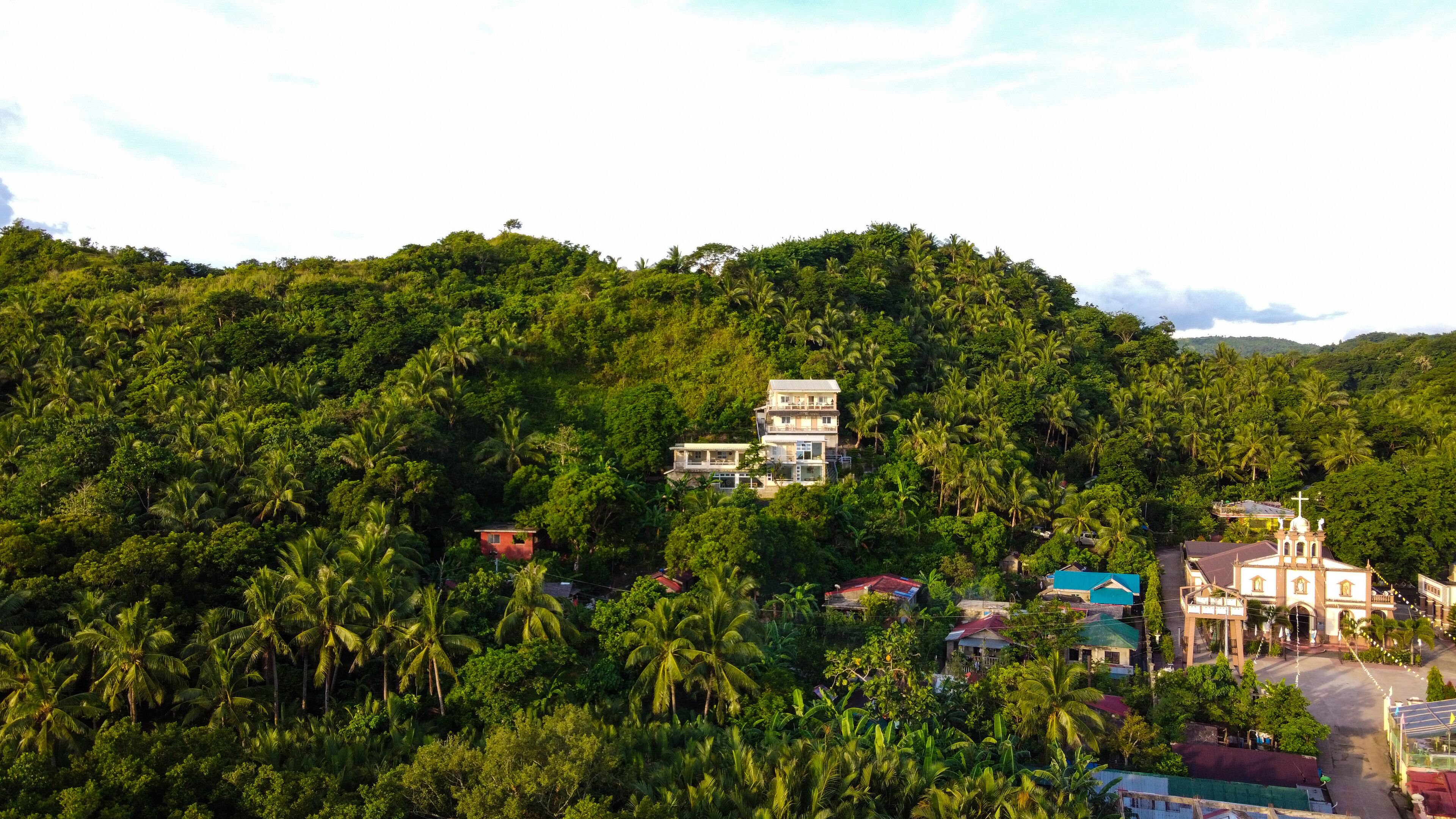Un immeuble à plusieurs étages, entouré d’une végétation tropicale luxuriante, qui ressemble probablement à un complexe hôtelier ou à un hôtel.