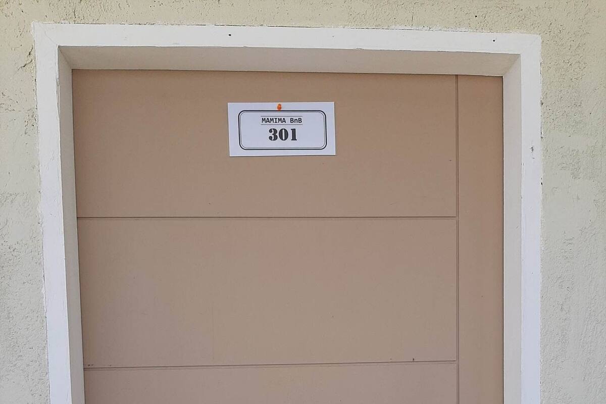 A door with a sign above it reading "MAMIMA BnB 301".