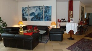 Una sala de estar con un conjunto de sofá, dos lámparas, una chimenea y una mesa con mantel blanco.