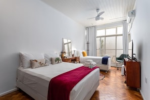A spacious bedroom with a large bed, a desk, a chair, and a television. - Vp101a Zona1 in Rio de Janeiro (Rio de Janeiro)