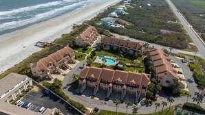 A coastal resort with multiple buildings, a swimming pool, and a beach view. - Spyglass 32 by Distinctive Beach Rentals (St. Augustine)