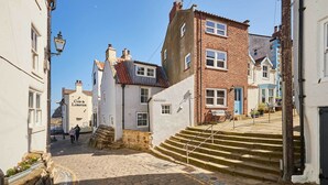 A narrow street with stone steps leading to a building labeled 'Cod & Lobster.' - Host & Stay | Sea Haven (Staithes)