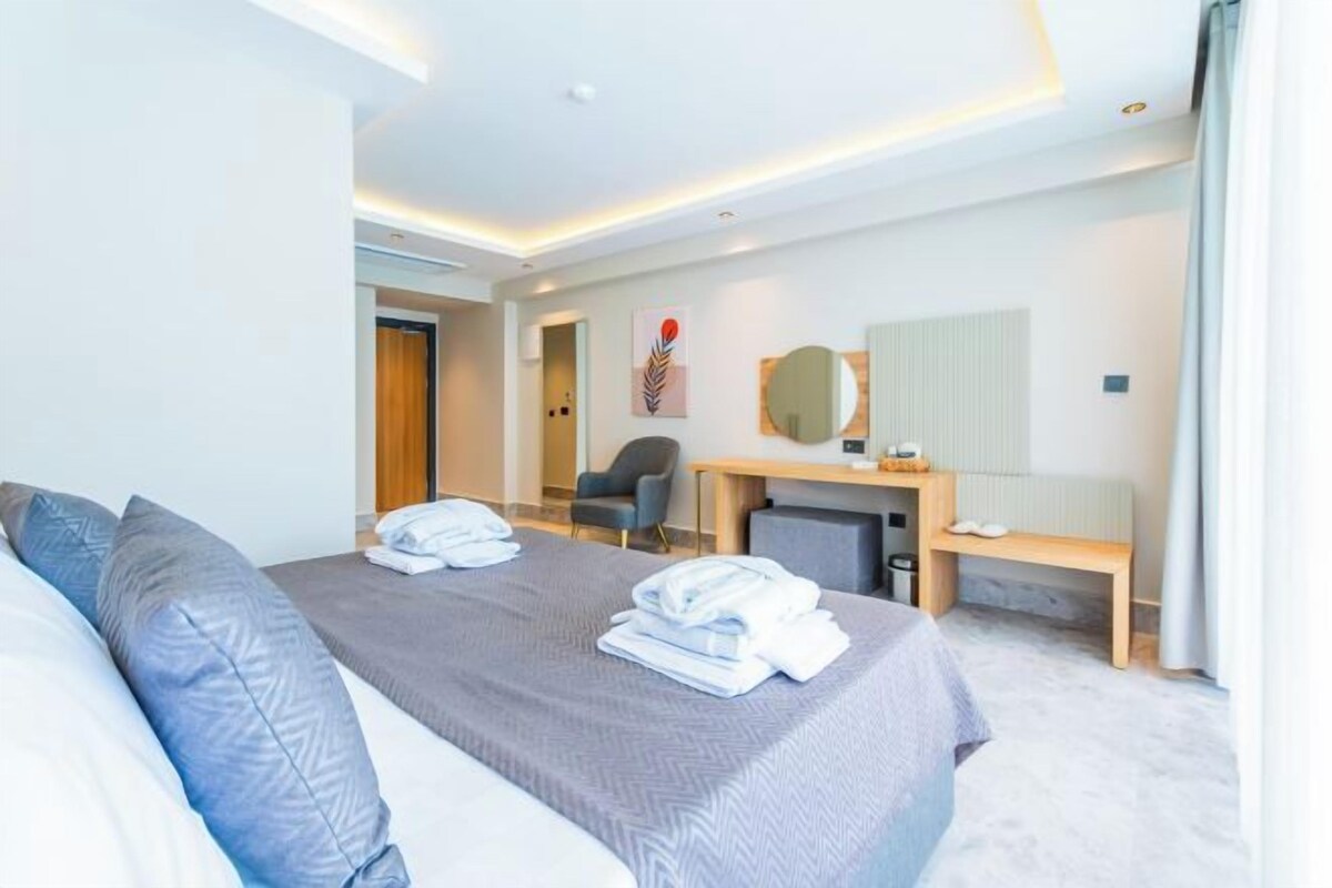 A modern hotel room with two beds, a desk, and a chair.