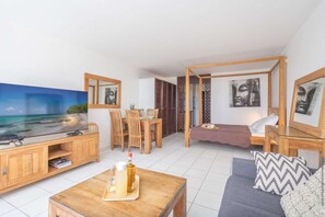 A modern room with a TV, wooden furniture, a bed, and artwork.