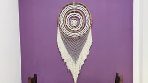 A dining area with a purple wall, a woven dreamcatcher, and two wooden chairs with colorful cushions. - Charming studio with a nice pool (Playa del Carmen)