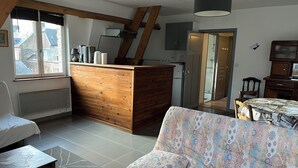 Un espacio habitable compacto con kitchenette, comedor y dormitorio.