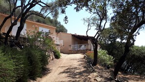 A gravel path leading to a building with a stone facade and a balcony. - Close to the beaches, spacious, air conditioning, panoramic view of the gulf!  (OLMETO)