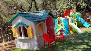A children's play area with a small house, slides, and climbing structures. - Close to the beaches, spacious, air conditioning, panoramic view of the gulf!  (OLMETO)