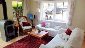 Un salon avec une cheminée, un canapé, un fauteuil et une table basse.