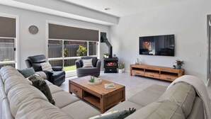 A modern living room with a sofa, chairs, a coffee table, a fireplace, and a TV. - The Witton Yarrawonga - Spring Offer (Yarrawonga)