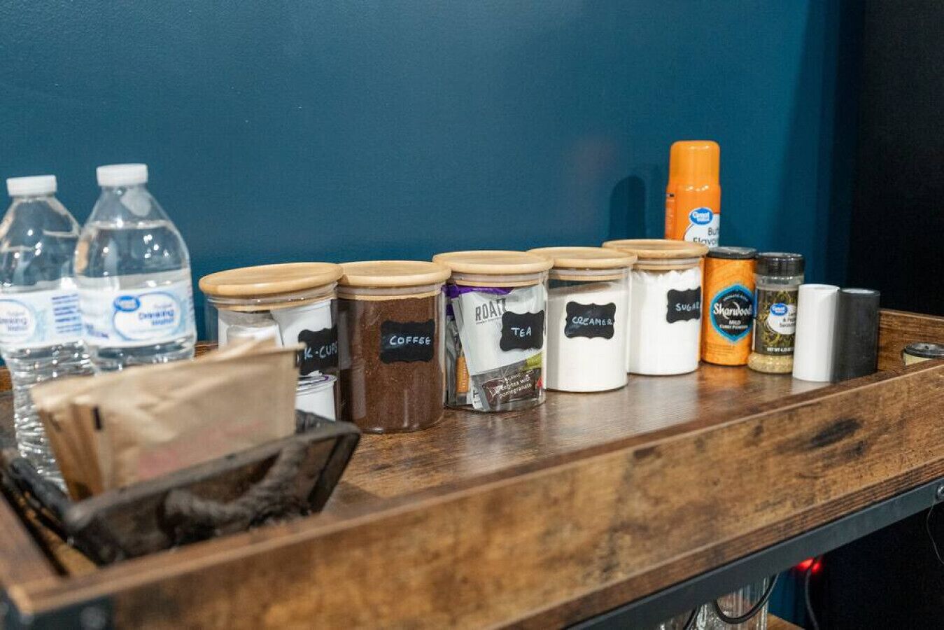 En bardisk med ett urval av drycker och tillbehör, inklusive kaffe, te och socker.