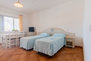 A room with two beds, a desk, and a television. - Le Residence del Golfo Orosei (Orosei (NU))