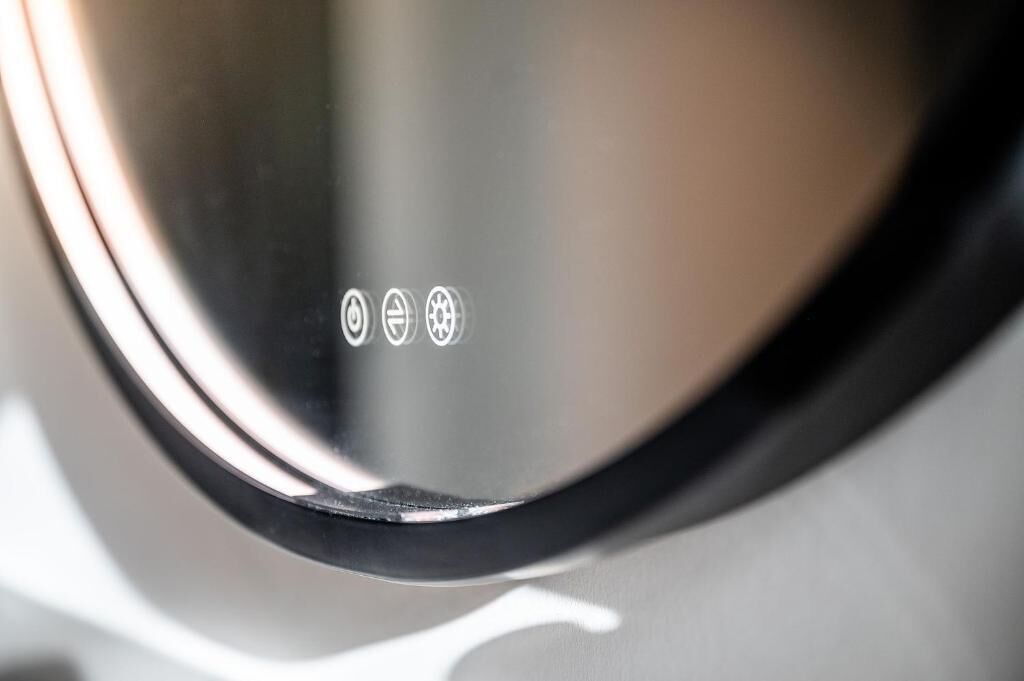 A close-up of a metallic object with three symbols: a circle with a cross, a circle with a diagonal line, and a circle with a gear.