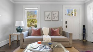 Ein Wohnzimmer mit einer Couch, einem Couchtisch und Kunstwerken an der Wand.