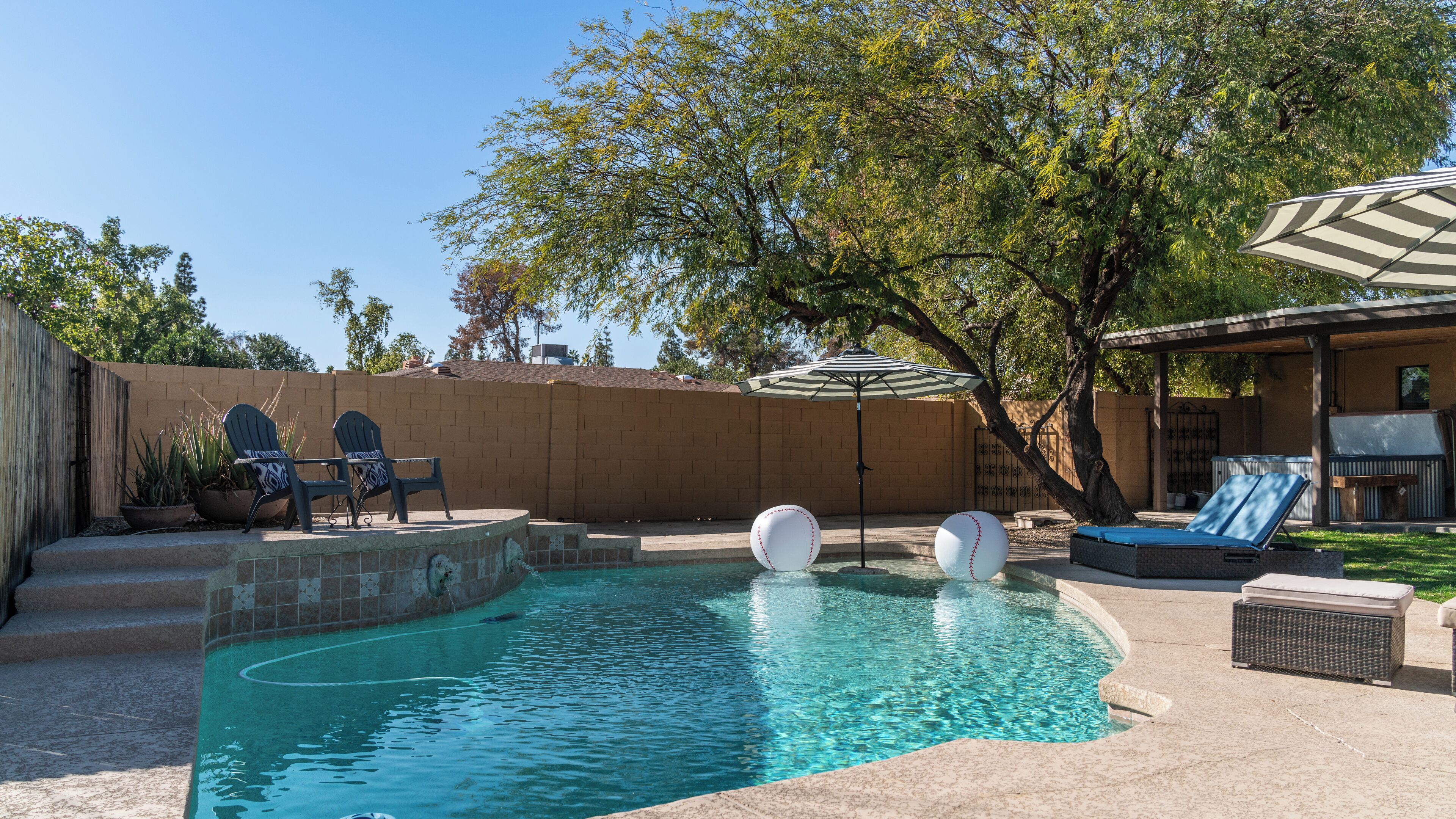 Takapihalla on uima-allas, kaksi Adirondack-tyylistä puutarhatuolia, suuri puhallettava pallo ja katettu terassialue.