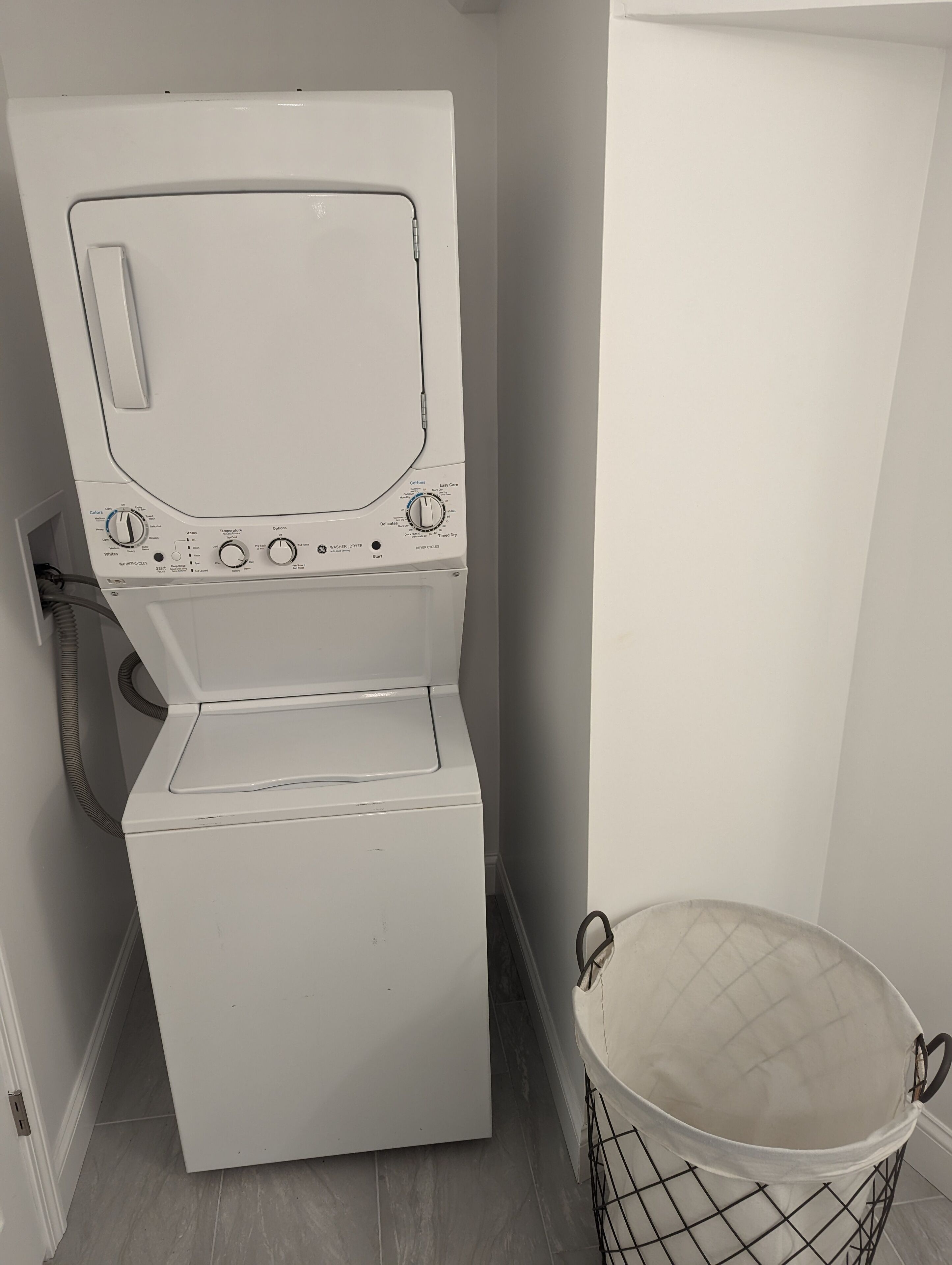 A compact, white front-loading washer and dryer unit with a control panel featuring multiple settings.