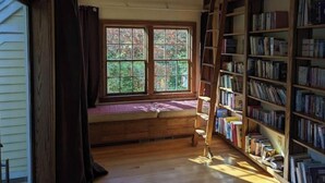 A room with a large window, a wooden ladder, and a bookshelf filled with books. - Spacious vacation townhome unit with a pool (Weston)