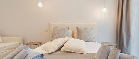 A hotel room with a bed, pillows, and towels.