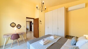 Ein Schlafzimmer mit einem Bett, einem Schreibtisch, einem Stuhl, einem Kleiderschrank und einer Deckenleuchte.
