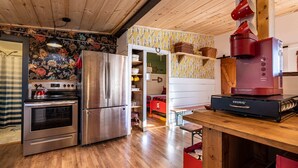 Cocina compacta con electrodomésticos de acero inoxidable, piso de madera y una zona de kitchenette.