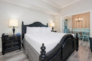 Ein ordentlich eingerichtetes Hotelzimmer mit einem Bett, Nachttischen, einem Schreibtisch und Stühlen.