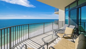 A balcony with a view of the ocean, furnished with chairs and a table. - ~Beach Front!~ Gorgeous 3 Bedroom Condo (Orange Beach)