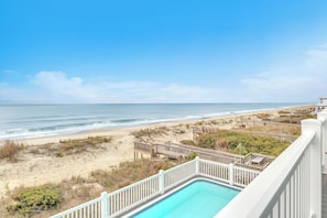 A pool with a view of the beach and ocean. - The Sale Fish: Modern Oceanfront Home with Private Pool and Elevator (Oak Island)