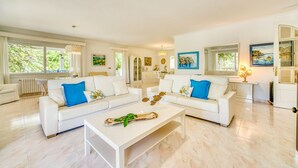 A spacious living room with two white sofas, a coffee table, and artwork on the walls. - Finca near the beach Casa Bonita in Mallorca (Colònia de Sant Jordi)