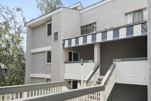 Un immeuble à plusieurs étages doté d’un balcon et d’un escalier.