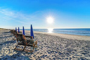 Une plage avec des parasols et des chaises de plage.