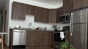 Eine moderne Küche mit Holzschränken, Edelstahlgeräten und einem Geschirrspüler.