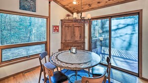 Un coin repas avec une table ronde, des chaises et un lustre.