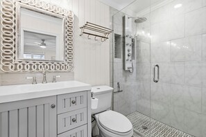 Regadera tipo lluvia, secadora de cabello, toallas, papel de baño 