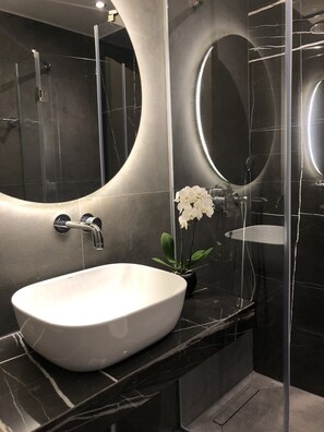 Deluxe appartement | Badkamer | Een douche, gratis toiletartikelen, een haardroger, handdoeken