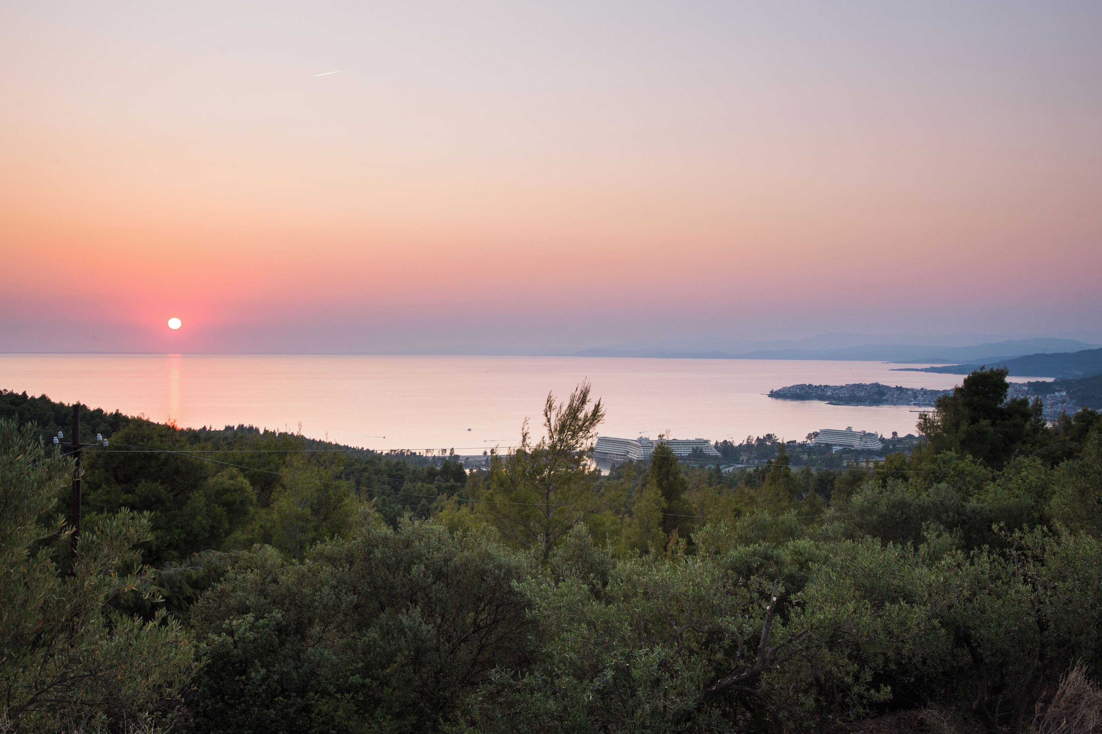 A sunset over a body of water with a city in the background.