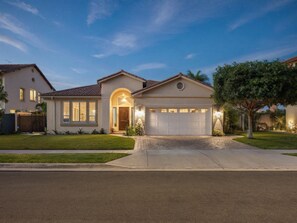 A residential house with a garage, a driveway, and a well-maintained lawn.