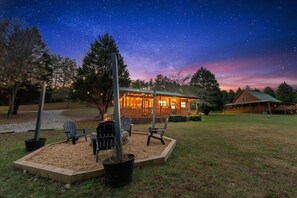 A lodge with a starry night sky, outdoor seating, and a large wooden structure. - *Timber & Tin 2*Cabin|Couples Getaway|Creek|HotTub (Suches)