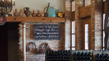 Un interior rústico con pared de ladrillo, una araña y una vinoteca.