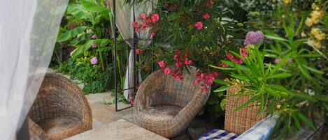 Un espacio al aire libre acogedor con mobiliario de mimbre y un mantel a cuadros.
